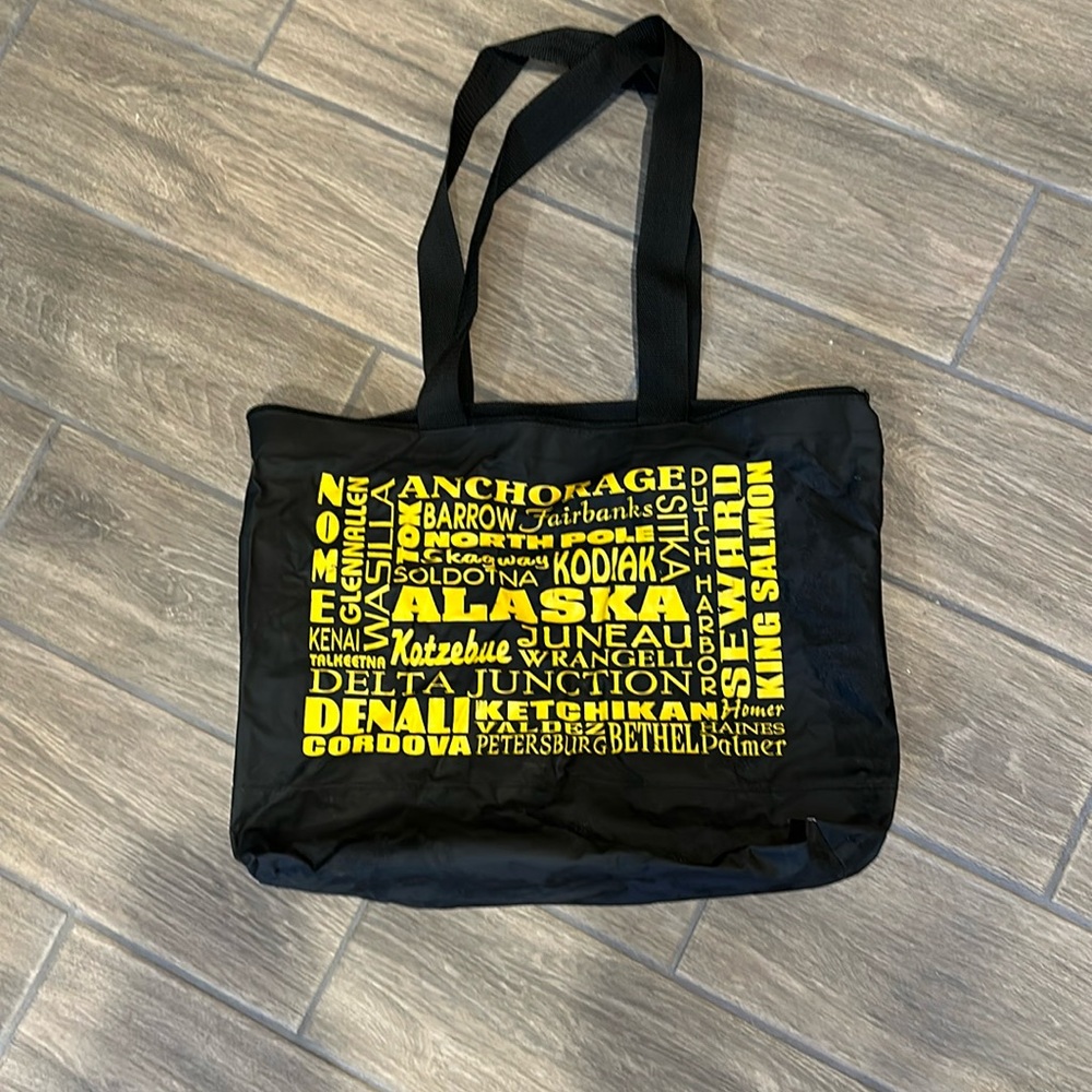 Alaska zip closure bag. Black with yellow writing.